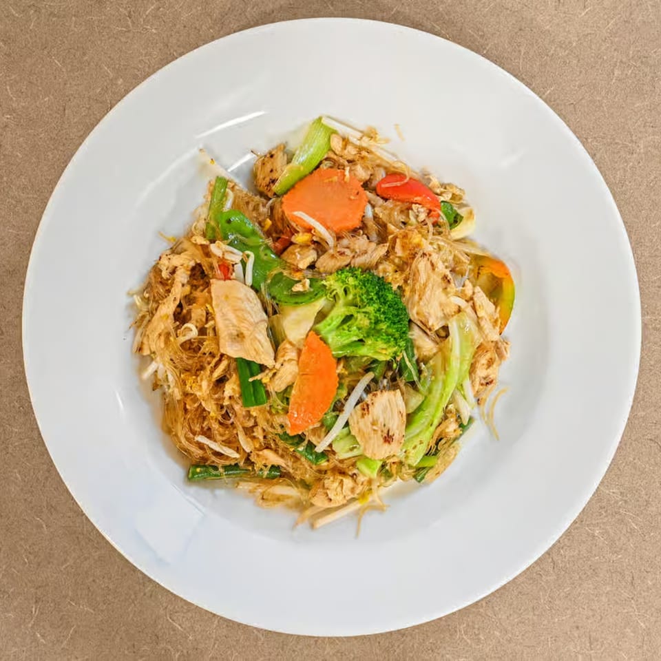 Truly Thai Restaurant's glass noodle dish with chicken, broccoli, carrots, and bean sprouts on a white plate.
