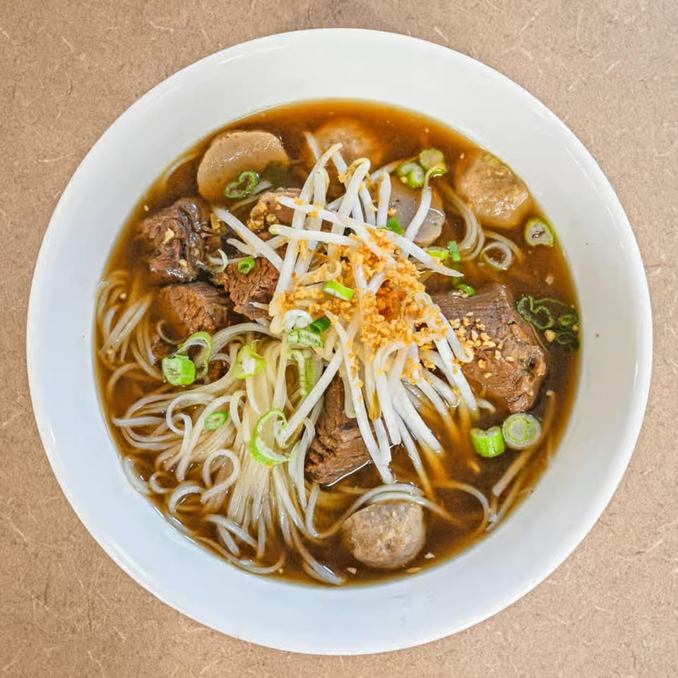 Truly Thai Restaurant's beef noodle soup with bean sprouts, green onions, and fried garlic.